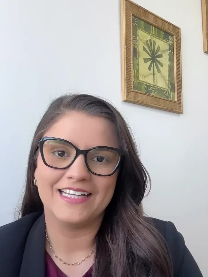 Mariana de óculos e blazer, sorrindo